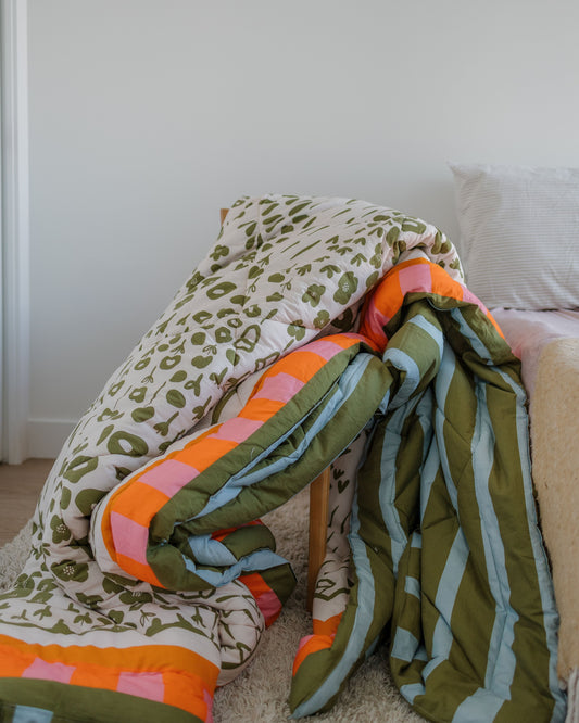 Colorful patterned blanket draped over a chair against a white wall