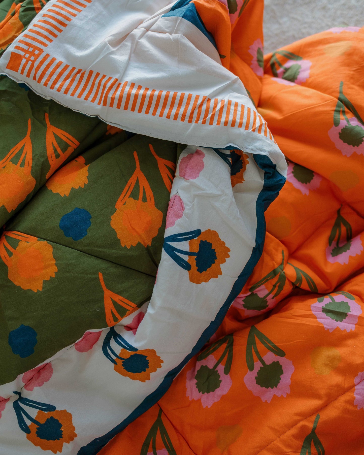 Colorful quilt with floral and abstract patterns on a neutral background