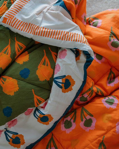 Colorful quilt with floral and abstract patterns on a neutral background